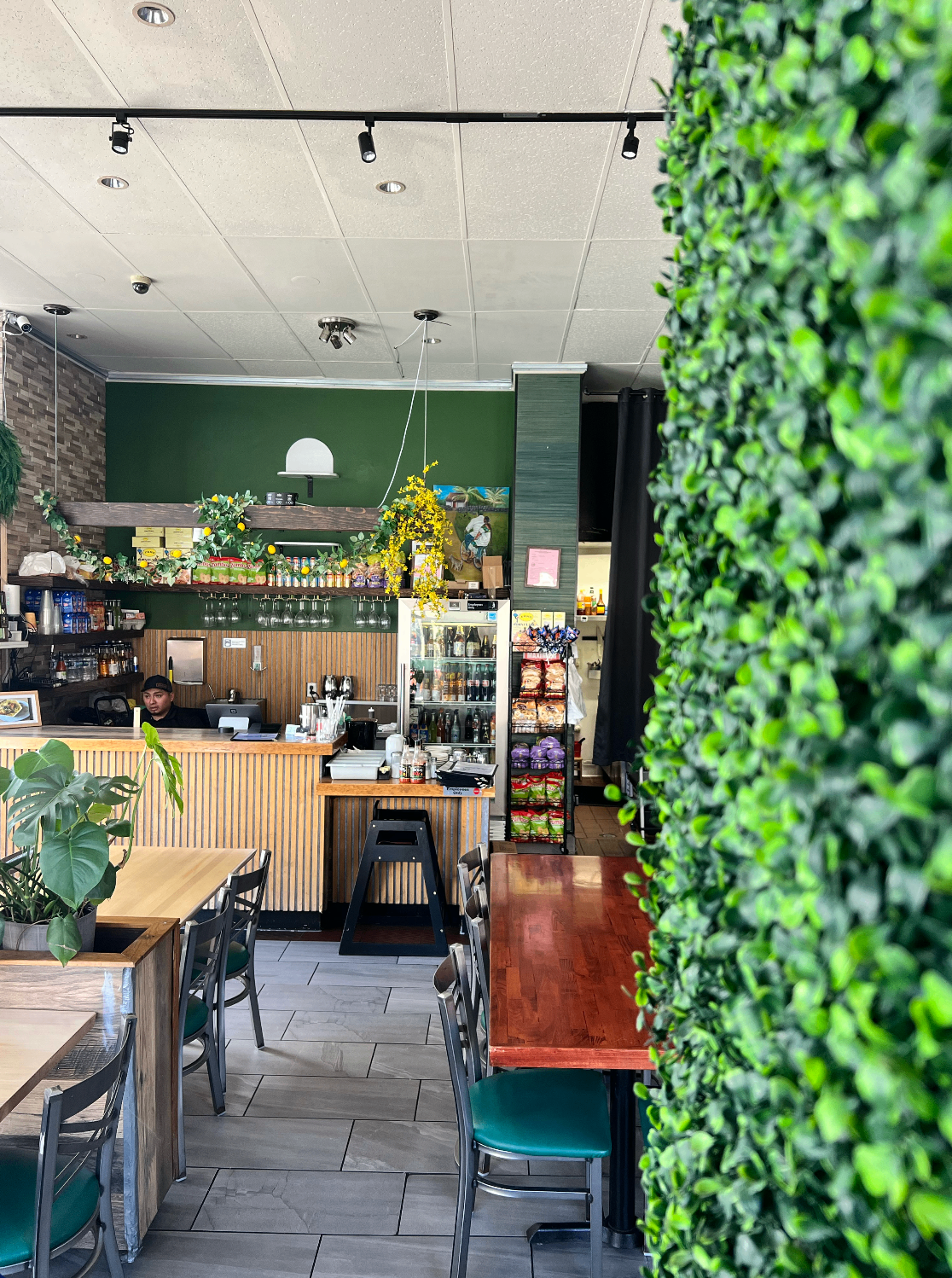 Dining area with green wall and lush plant divider